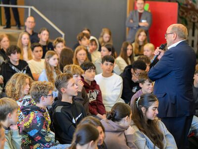 Landtagsvizepräsident Rainer Schmelzer spricht vor versammelten Schülerinnen und Schülern der Jahrgangsstufe 7